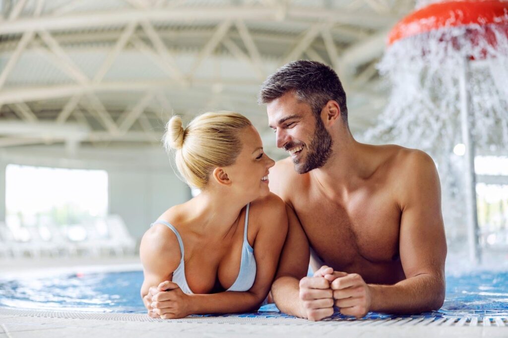A couple peacefully relaxing in a swimming pool surrounded by clear water and a tranquil atmosphere